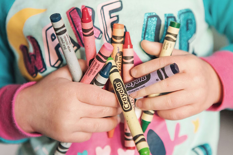 Image of child holding crayons